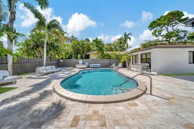 a swimming pool in a backyard with a fence at Waterfront Unit #5 20 Min Walk to Beach and Shops in Fort Lauderdale