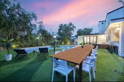 a wooden table and chairs in a yard with a pool at Sunny Miami Escape in Prime Location