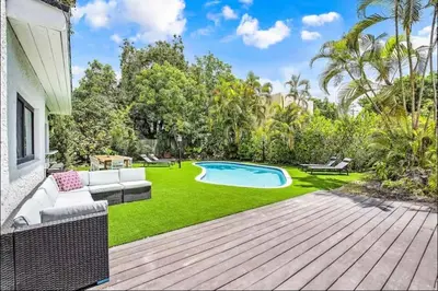 a backyard with a pool and green grass at Sunny Miami Escape in Prime Location