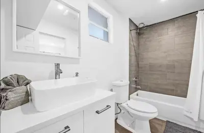 a white bathroom with a sink and a toilet and a tub at Sunny Miami Escape in Prime Location