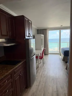 a kitchen with a refrigerator and a table with a view of the ocean at Direct Ocean View Condo,Balcony kitchen pool gym sauna valet parking direct beach access for perfect vacation in Sunny Isles Miami in Sunny Isles Beach