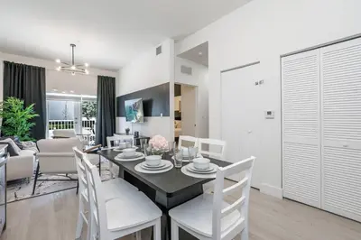 a dining room and living room with a table and chairs at Classy 2BR-2BA Oasis Beach Pool Parking EV Station in Hallandale Beach