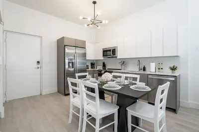 a kitchen with a dining room table and chairs at Classy 2BR-2BA Oasis Beach Pool Parking EV Station in Hallandale Beach