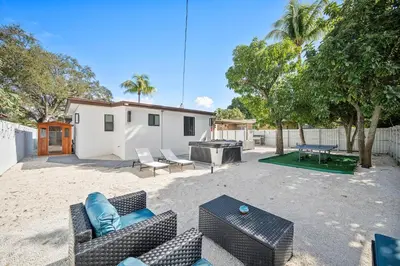 a patio with chairs and a table and a grill at Miami Hotel Home in North Miami