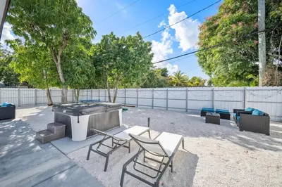 a backyard with a grill and chairs and a table at Miami Hotel Home in North Miami