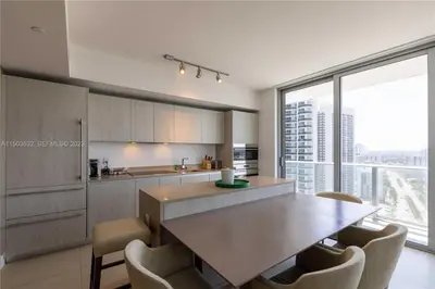 a kitchen with a table and chairs and a large window at Oceanfront dream W pool & beach access in Hollywood