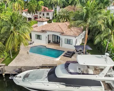 a boat is parked next to a house at The Rendez-Vous Villa Waterfront in Fort Lauderdale