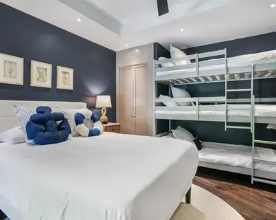 a bedroom with a large white bed and bunk beds at The Rendez-Vous Villa Waterfront in Fort Lauderdale