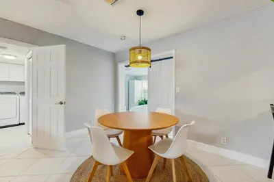 a dining room with a wooden table and white chairs at The Palms in Fort Lauderdale