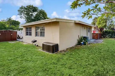 a small house in a yard with a green lawn at The Palms in Fort Lauderdale