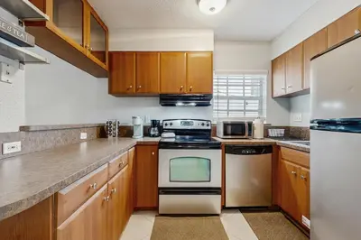 a kitchen with wooden cabinets and a stove top oven at The Palms in Fort Lauderdale