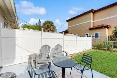 a patio with chairs and a table and a fence at The Palms in Fort Lauderdale