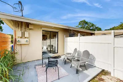 a patio with chairs and a table and a fence at The Palms A in Fort Lauderdale