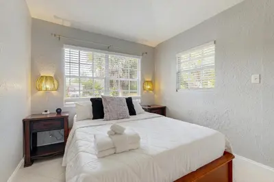 a bedroom with a large white bed and a window at The Palms B in Fort Lauderdale