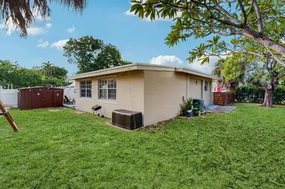 a small house in a yard with a green lawn at The Palms B in Fort Lauderdale