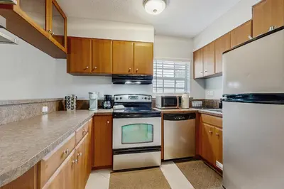 a kitchen with wooden cabinets and a stove top oven at The Palms B in Fort Lauderdale