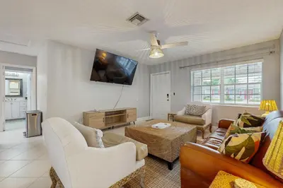 a living room with a couch and a tv on the wall at The Palms B in Fort Lauderdale