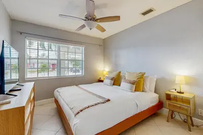 a bedroom with a large bed with a ceiling fan at The Palms B in Fort Lauderdale
