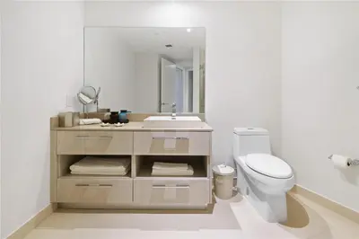 a bathroom with a sink and a toilet and a mirror at Lux Beachfront Retreat at Hyde Resort w OceanView in Hollywood