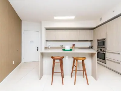 a kitchen with two bar stools and a counter at Lux Beachfront Retreat at Hyde Resort w OceanView in Hollywood