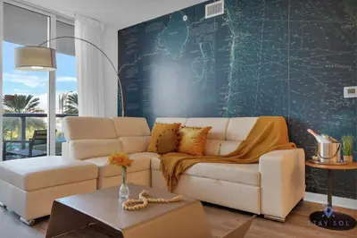 a living room with a white couch and a green wall at Spectacular Near Beach 2 BR Apartment in Hallandale Beach