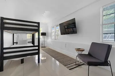 a bedroom with a bed and a chair and a television at 7BD Downtown Oasis - Pool - 10 Mins to South Beach in Miami