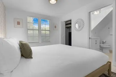 a white bedroom with a large bed and a bathroom at 7BD Downtown Oasis - Pool - 10 Mins to South Beach in Miami