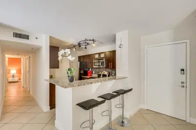 a kitchen with a counter and stools in a room at Resort Condo By Aventura Mall! Gated Community in Aventura