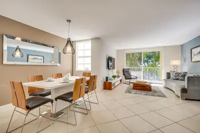 a dining room and living room with a table and chairs at Resort Condo By Aventura Mall! Gated Community in Aventura