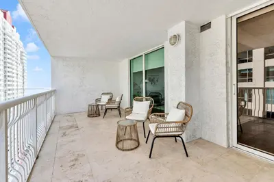 a patio with chairs and tables on a balcony at Upscale4 Brickell Retreat with Bay n City Views in Miami