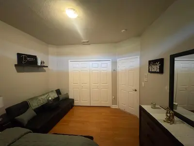 a living room with a couch and two white doors at The B Shared Resident in Miramar