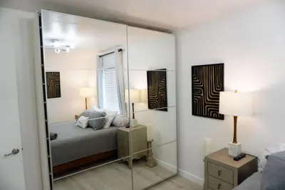 a bedroom with a bed and a large mirror at Pool House in Fort Lauderdale in Fort Lauderdale