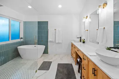 a bathroom with a tub and two sinks and a bath tub at Plantation Pool Home with Hot Tub Sleeps 10 in Plantation