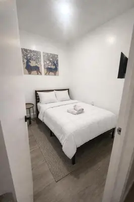 a bedroom with a white bed with two pictures on the wall at Santorini Hollywood in Hollywood