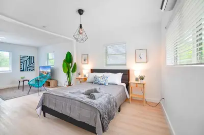 a bedroom with a large bed in a room with white walls at Miami Studio a Few Steps to the Beach in Miami