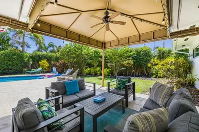 an outdoor patio with couches and a table at Spacious Miami Home with Private Pool & Parking in Biscayne Park