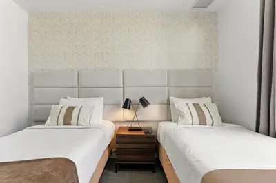 two beds sitting next to each other in a bedroom at Miami Beach 2Q Localização Incrível a Pé da Praia in Miami Beach