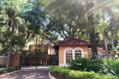 a small house with a gate and palm trees at The Yacht Club at Aventura Miami 4405 in Aventura