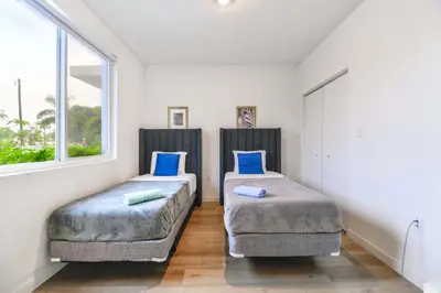 a bedroom with two beds with blue pillows at Miami Townhouse Stay with Free Parking in Miami