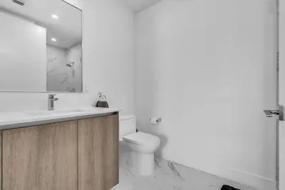 a white bathroom with a toilet and a sink at Chic OceanView 2 Bedroom with Free Parking Pool Jacuzzi in Sunny Isles Beach