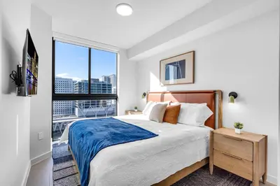 a bedroom with a bed and a large window at Corner Chic 2 Bedroom Downtown with Rooftop Pool & Views in Miami