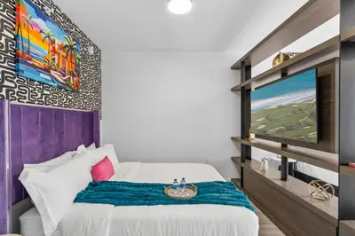 a bedroom with a bed and a tv on a wall at Luxxe Suite Downtown Brickell in Miami
