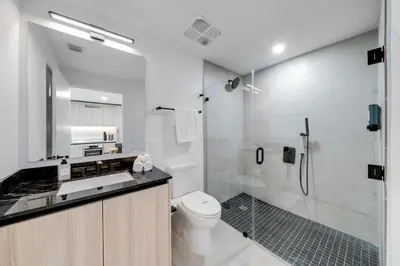 a bathroom with a shower and a toilet and a sink at Sleek Escape-Resort-Style Stay with Pool Spa & more in Miami