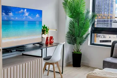 a living room with a tv and a plant at Sleek Escape-Resort-Style Stay with Pool Spa & more in Miami