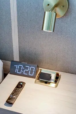 a alarm clock on a bed with a clock and a remote control at Sleek Escape-Resort-Style Stay with Pool Spa & more in Miami