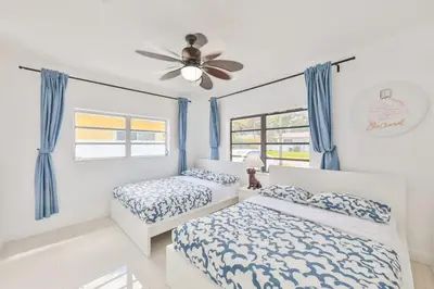 a bedroom with two beds and a ceiling fan at Aventura Ives Family Home in Miami