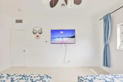 a bedroom with a mask and a tv on the wall at Aventura Ives Family Home in Miami