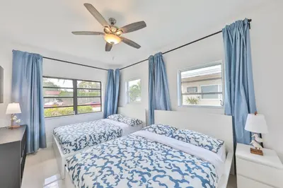 a bedroom with two beds and a ceiling fan at Aventura Ives Family Home in Miami