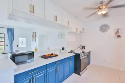 a kitchen with blue cabinets and a bowl of fruit on the counter at Aventura Ives Family Home in Miami