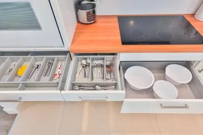 an open kitchen drawer with white plates and utensils at Family Grand Advantage in Hollywood